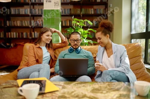 Preview: Employee shows teammates business solutions on laptop screen at coworking space