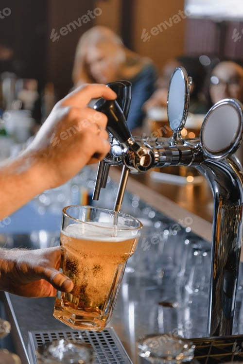 Preview: cropped image of barman pouring beer in glass at bar