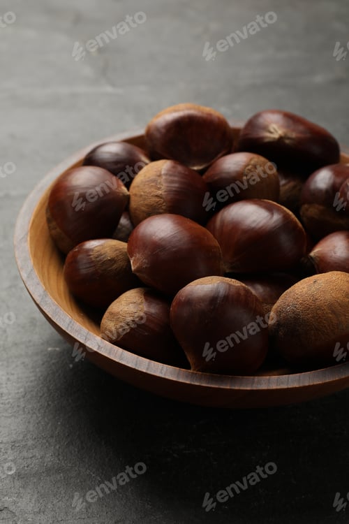 Preview: Roasted edible sweet chestnuts in bowl on grey table, closeup