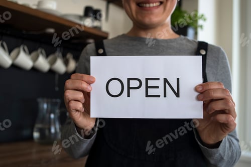 Preview: Woman waitress with OPEN sign in cafe
