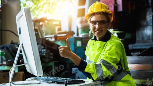 Preview: female industrial engineer works on personal computer show thumb up for OK after checking equipment