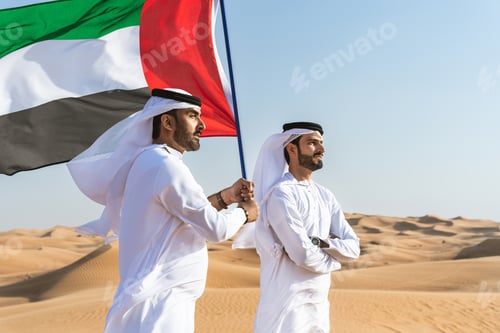 Preview: Two middle-eastern emirati men wearing arab kandura bonding in the desert