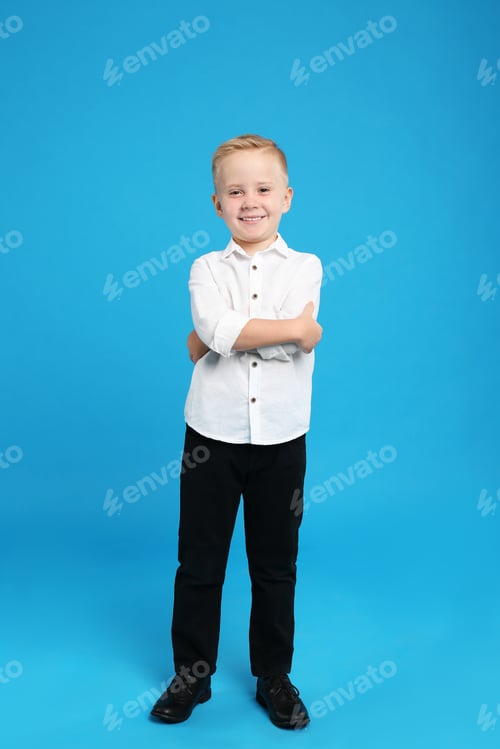 Preview: Full length portrait of cute little boy on light blue background