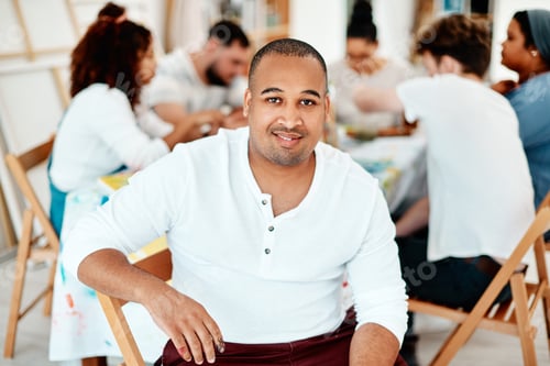 Preview: Cropped portrait of a handsome young man sitting with his friends during an art class in the studio
