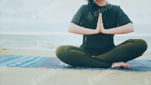 Preview: Woman in sports clothing practicing yoga and meditation on beach seaside in bad rainy weather