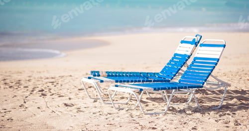 Preview: White lounge chairs on a beautiful tropical beach at Maldives