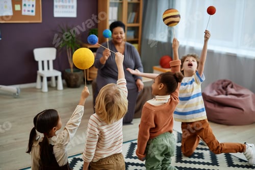 Preview: Diverse group of kids playing with planet models enjoying class in preschool