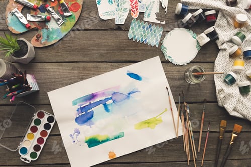Preview: Top view of artist sketches drawn with watercolor paints and brushes on a table