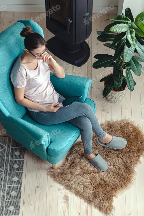 Preview: Young woman using tablet while sitting in a comfortable chair