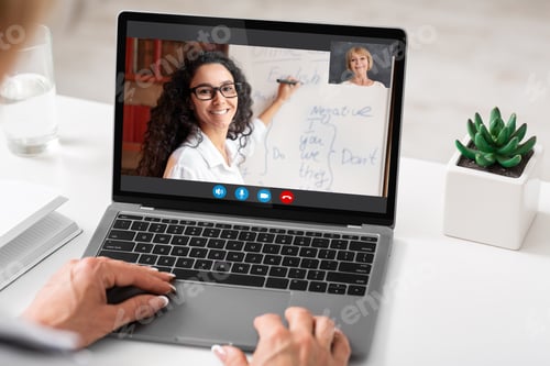Preview: Unrecognizable woman sitting at desk using laptop, having video call