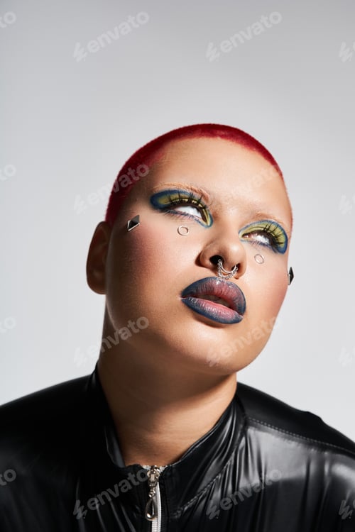 Preview: Young woman with short pink hair showcases her bold style and unique makeup in a studio