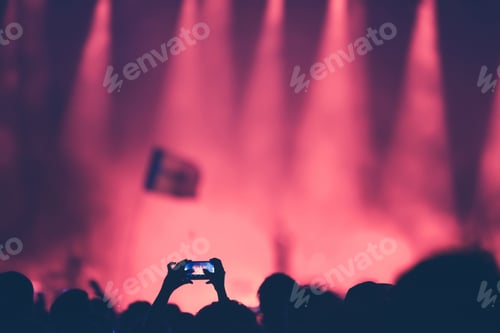 Preview: Fan taking photo of concert at festival with a smart phone