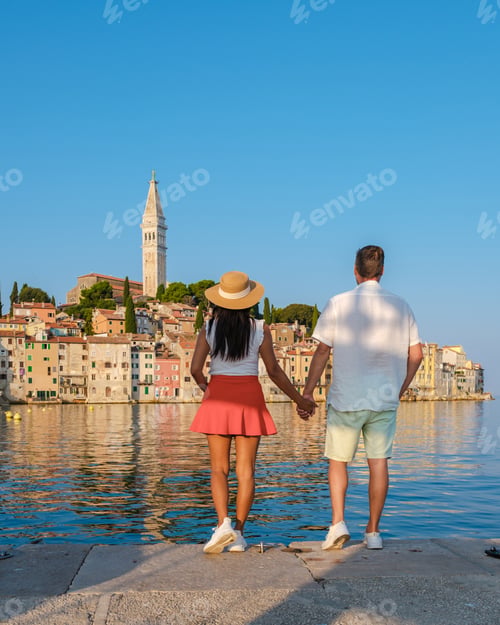 Preview: Couple enjoying a romantic stroll by the harbor in Rovinj, Croatia on a sunny day