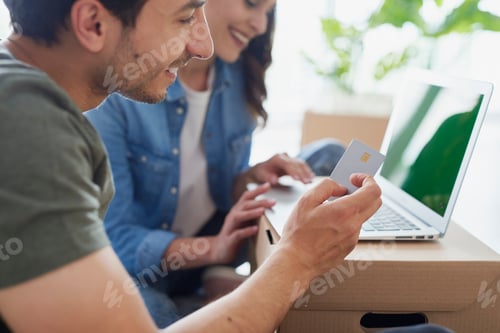 Preview: Young couple doing online shopping on laptop