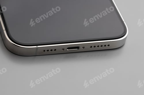 Preview: Close up of charging port of modern smartphone on gray background