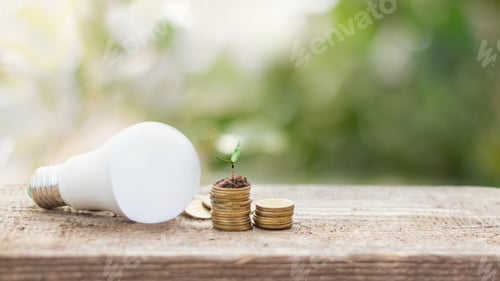 Preview: LED bulb on coin stacks with growing plant - Concept of saving energy, electric and eco business