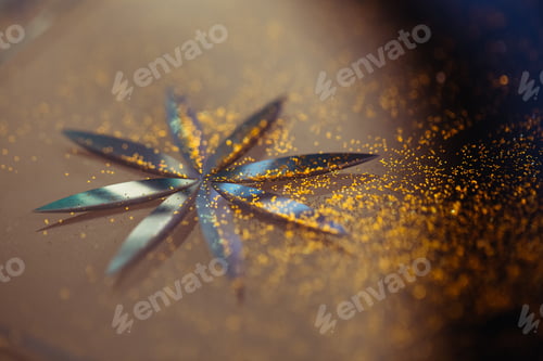 Preview: Shallow focus - Blue holiday background with star carved in glass and golden glitter.