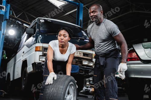 Preview: Mechanic working in a garage, holding his tools and turning a wheel while he is there.