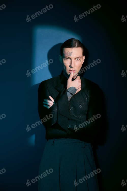 Preview: Handsome young man exudes confidence in stylish attire against a dramatic backdrop