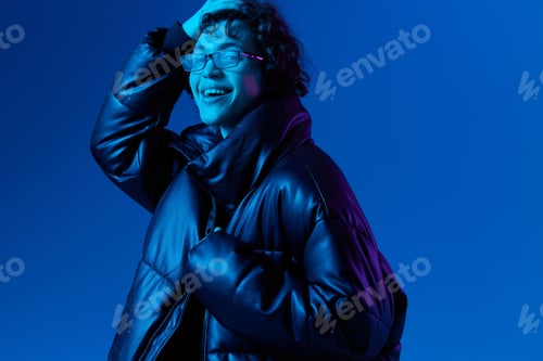 Preview: Man in winter down jacket model poses with a smile with glasses, hipster lifestyle, portrait blue
