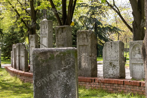 Preview: Side shot of many old stone graves in the park with trees in Nis, Serbia on a sunny day