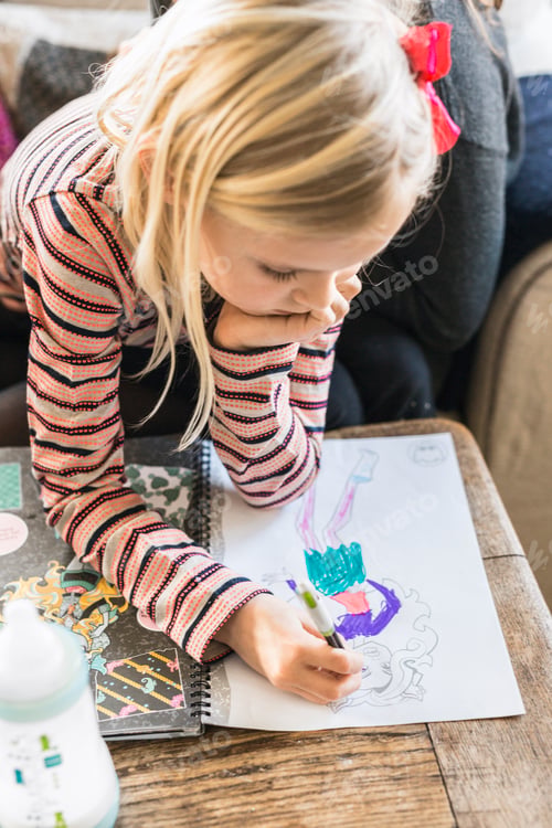 Preview: Little girl drawing at table in house