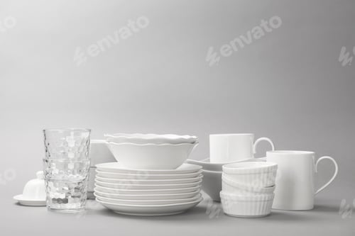 Preview: Set of clean tableware on grey background. Washing dishes