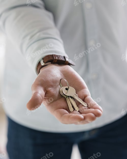 Preview: the hand of a white man with the keys to the new apartment he bought