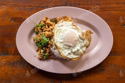 Preview: Overhead view of Prad Ka Pao, popular Thai steet food made up of fried minced pork with basil and