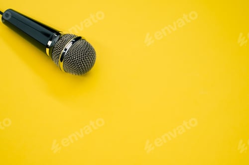 Preview: High angle shot of a microphone on a yellow surface