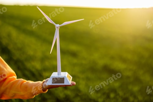 Preview: Person holds toy wind generator on field