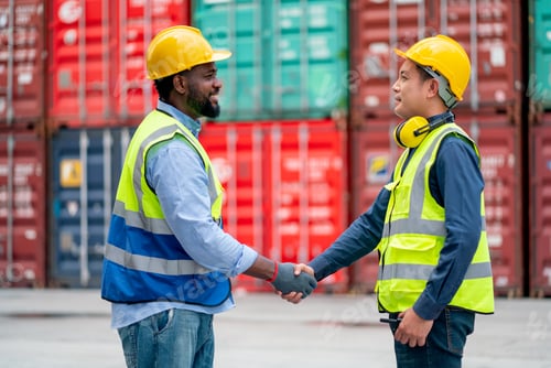 Preview: African American worker or technician shake hands with Asian staff in cargo container workplace