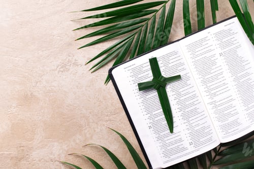 Preview: Palm Sunday concept. Palm cross on open Holy Bible and palm leaves. Reminder of Jesus sacrifice and