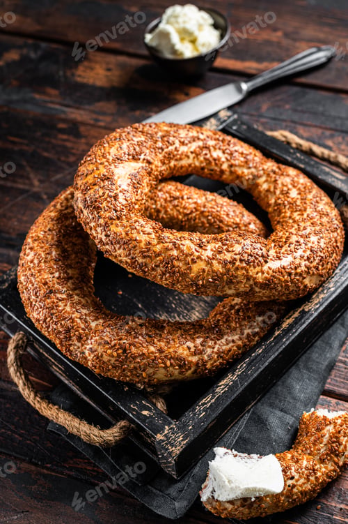 Preview: Stack of fresh baked Turkish simit bagel with kaymak. Wooden background. Top view