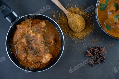 Preview: Massaman curry in a frying pan with spices on the cement floor
