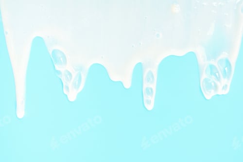 Preview: liquid moisturizing shampoo dripping down on blue background close-up.