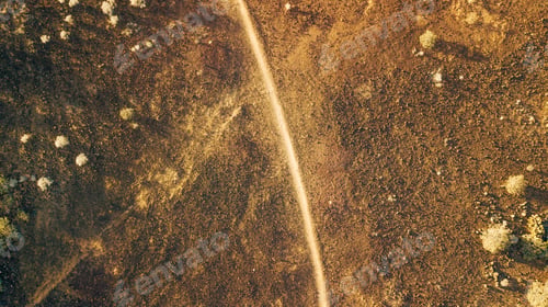 Aperçu: View from drone of desert landscape with a path through it, arid landscape with little vegetation