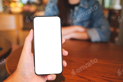 Preview: Mockup image of a man holding mobile phone with blank screen with a woman in background