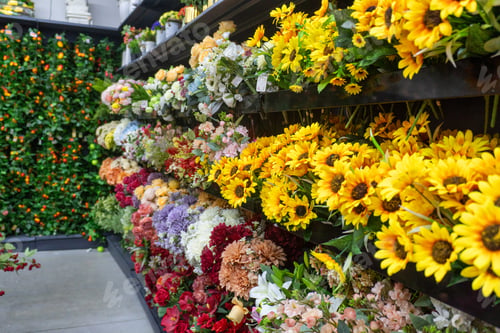 Preview: Colorful display of a wide variety of artificial floral arrangements on the shelves.