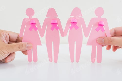 Preview: Hands holding paper girls with pink ribbon as a symbol of breast cancer awareness