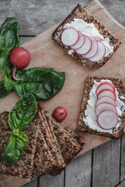 Preview: Top view Fitness bread with cottage cheese, radish and basil on rustic wood background, closeup