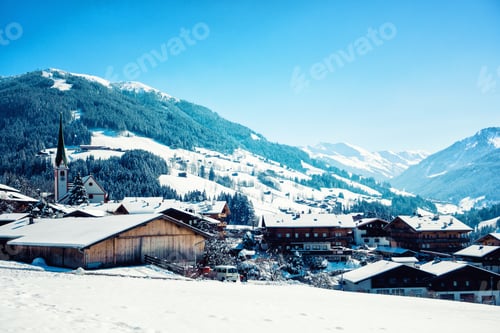Preview: Close-up shot of wooden houses on the snowy forest background in Alpbach, Tyrol, Austria.