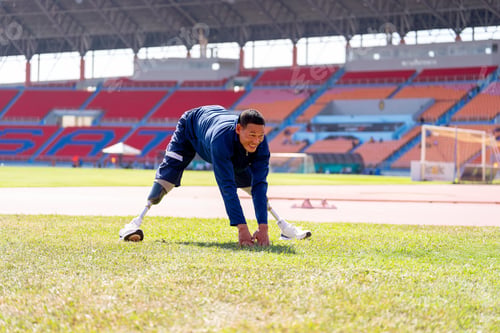 Preview: Asian para-athletes with prosthetic blades sprint on a running track at stadium.