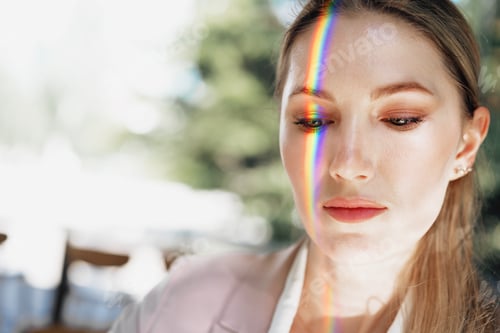 Preview: Portrait of an attractive woman with rainbow light across face