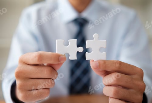 Preview: Businessman Holding Puzzle Pieces Symbolizing Problem Solving and Strategy