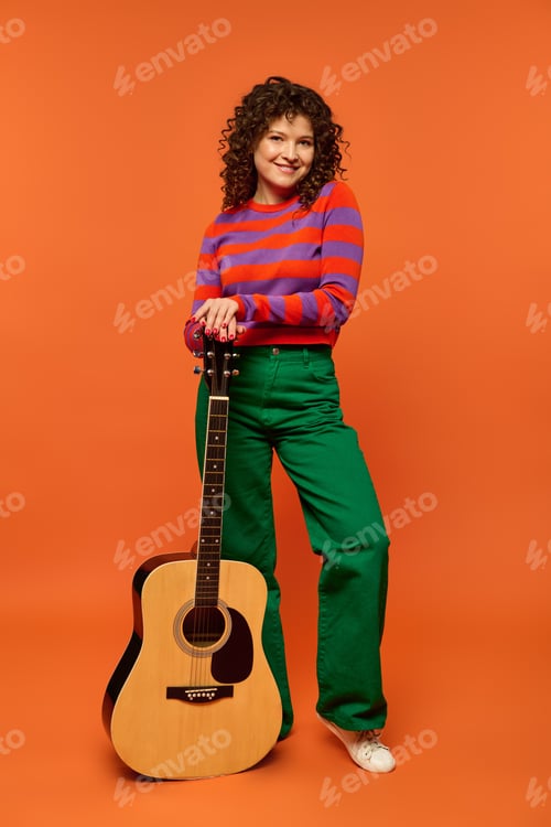 Preview: Colorful girl posing with guitar against orange background