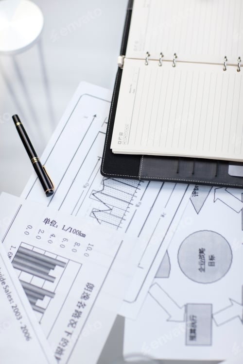 Preview: Notepad and business charts on desk