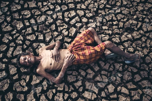 Preview: Elderly men lay flat, hands placed on the belly on dry and cracked soil, global warming