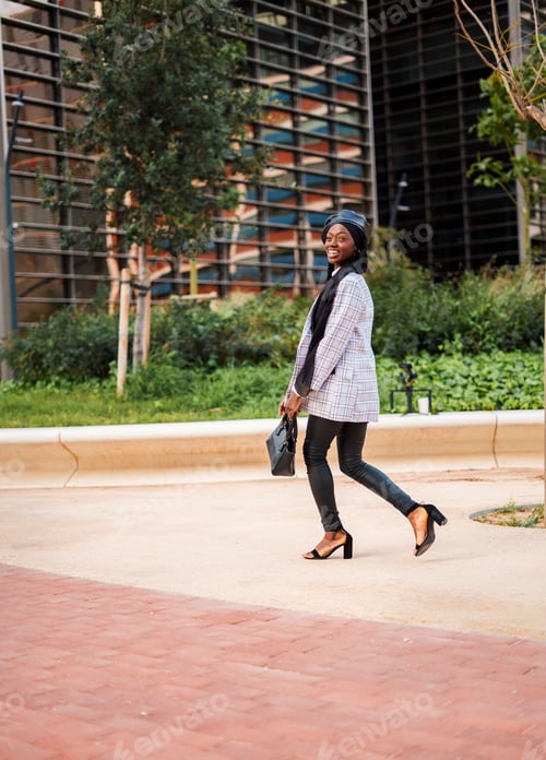 Preview: Stylish black woman enjoying pleasant walk in city park