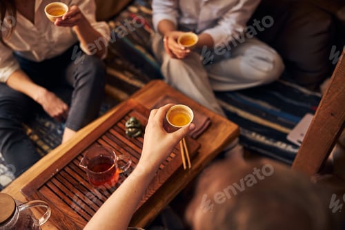 Preview: Group of friends drinking tea in cozy cafe